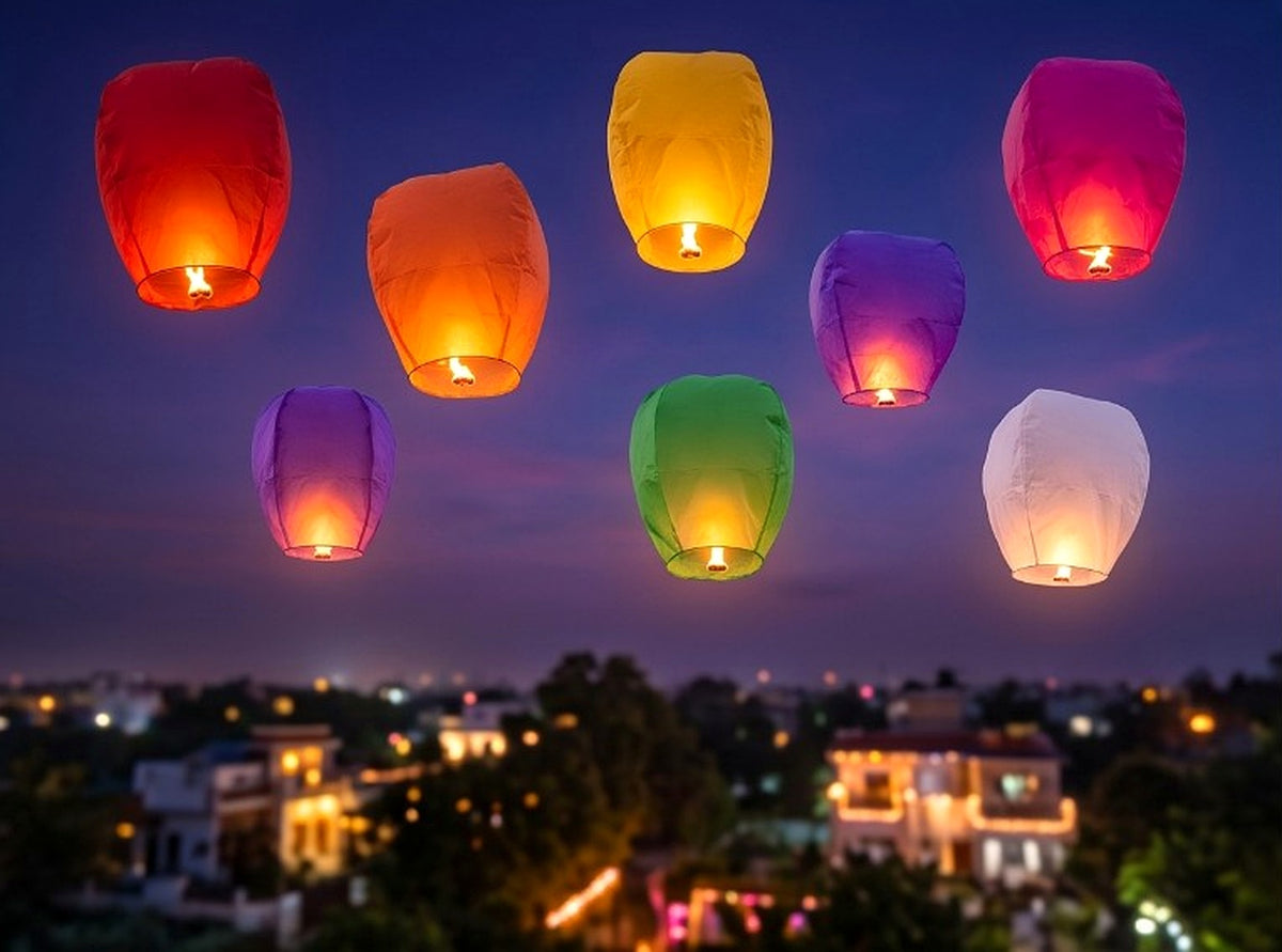 Eight colourful sky lanterns glowing against a night sky