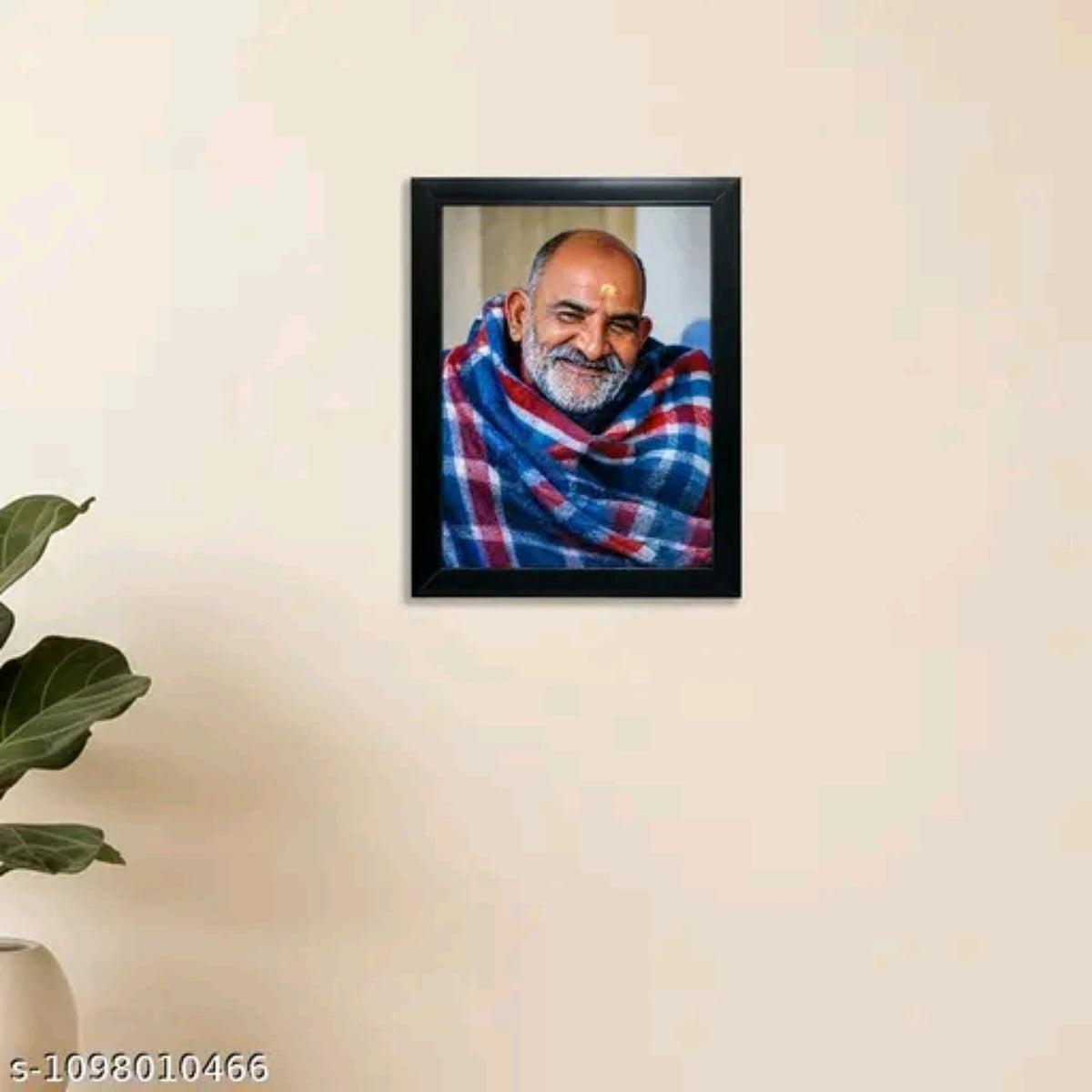 Neem Karoli Baba black photo frame displayed on a wall