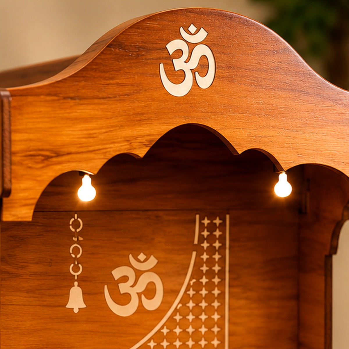 Close-up of the Om symbol and carved canopy on the wooden mandir