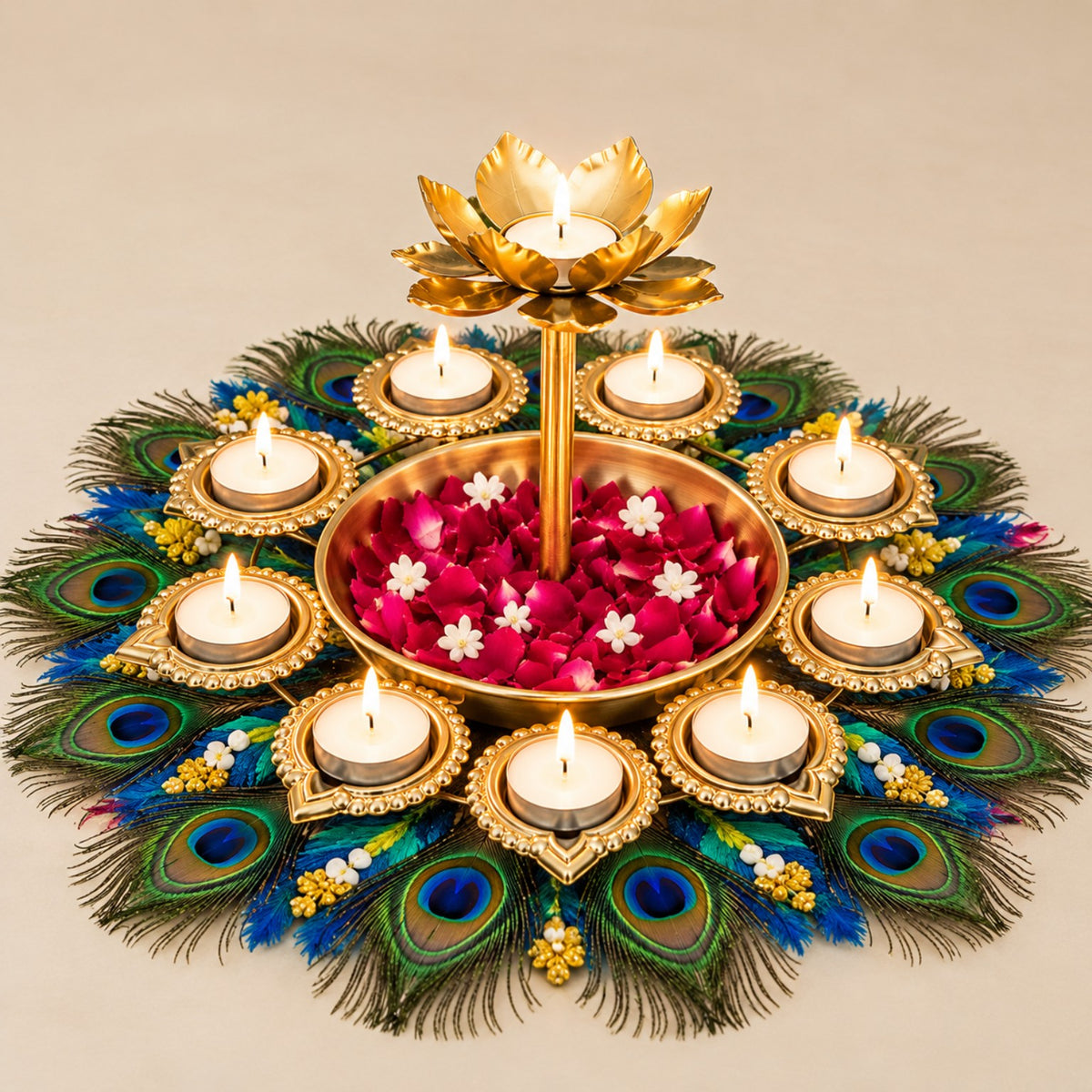Actual product photo of an ornate gold-tone Diwali diya centerpiece with a raised lotus candle holder, surrounding tea-light holders, central flower tray, and peacock-feather base on a clean beige background