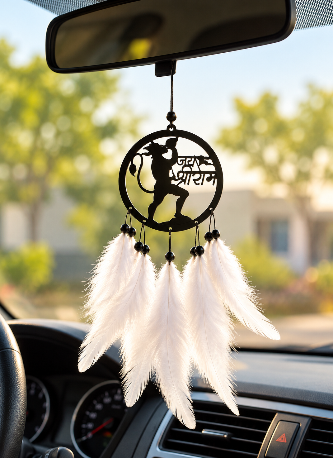 Close-up of Hanuman Ji Jai Shri Ram feather car hanging inside a car