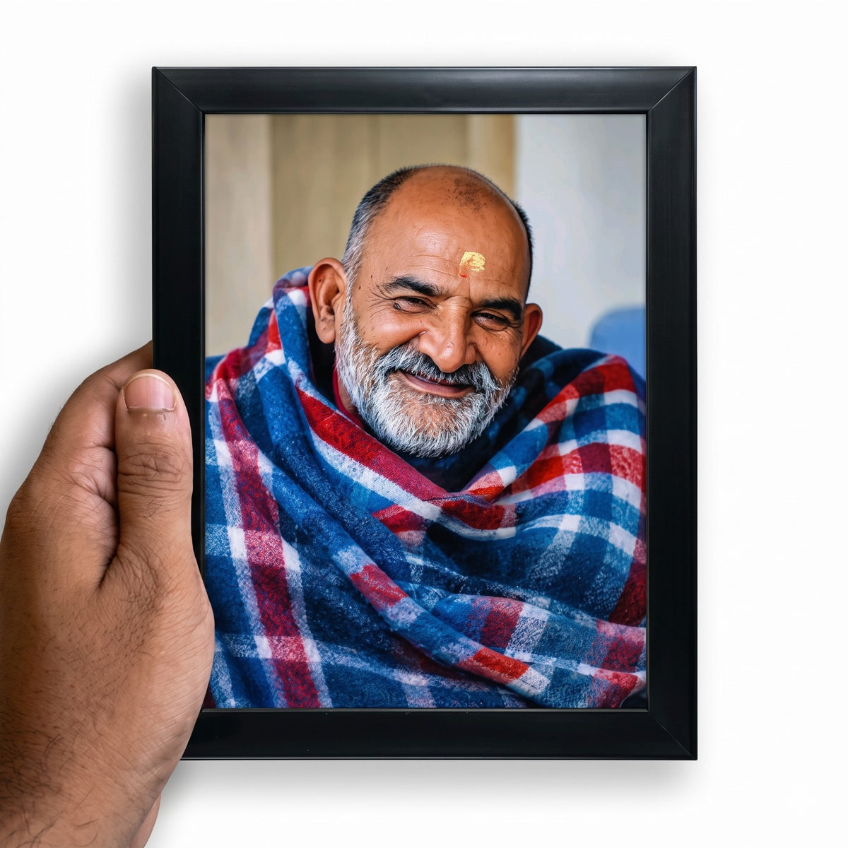 Neem Karoli Baba portrait in a black photo frame held in hand